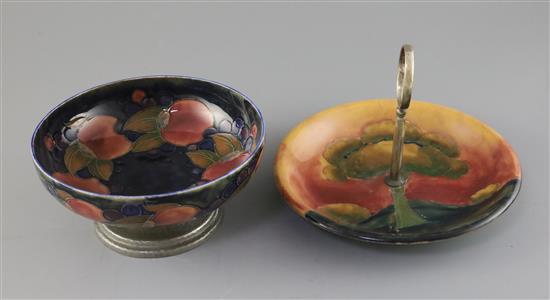 A Moorcroft pomegranate and Tudric pewter mounted bowl and an Eventide cake dish, c.1920-5, diameter 19cm and 22cm, both cracked